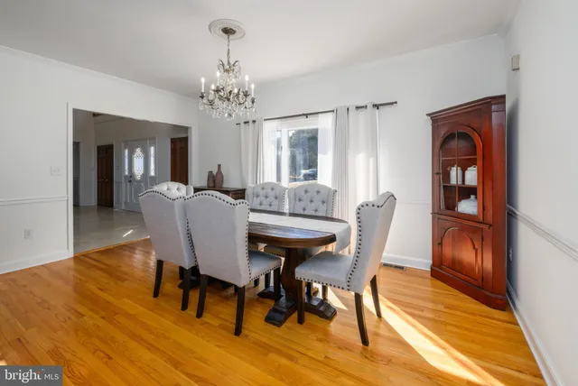 a kitchen with stainless steel appliances kitchen island granite countertop a table chairs in it and wooden floors