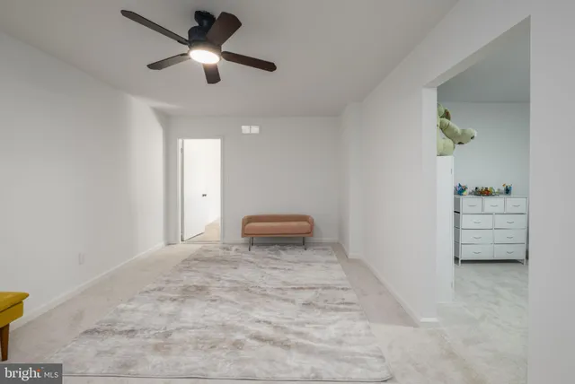 a spacious bedroom with a bed and a flat tv screen on dresser