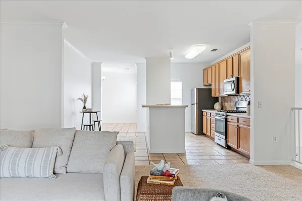 a living room with furniture and a view of kitchen