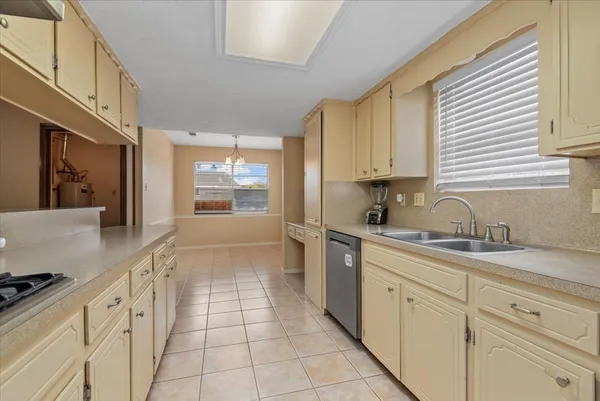 a kitchen with granite countertop white cabinets white appliances a sink and a window