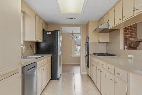 a kitchen with granite countertop a sink stove and refrigerator
