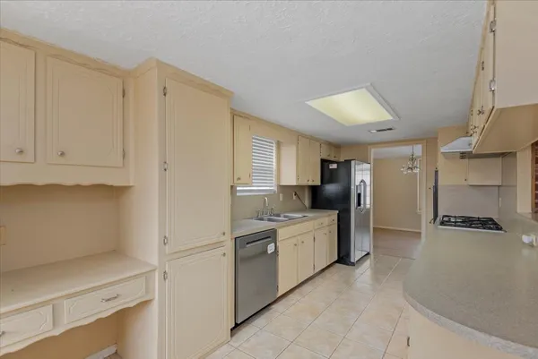 a kitchen with white cabinets and refrigerator