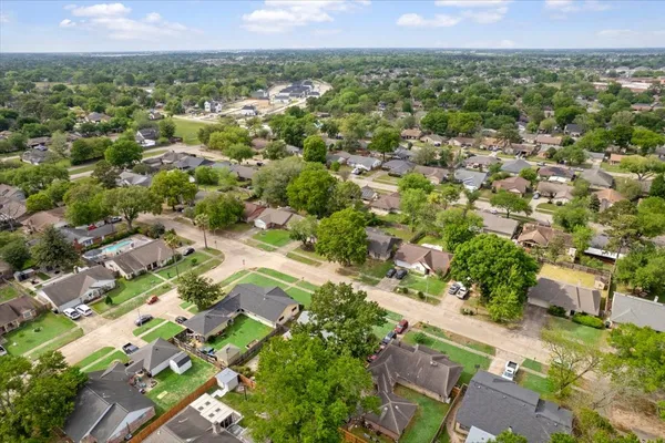 an aerial view of residential houses with outdoor space and trees