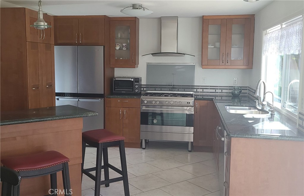 719 Cobb Avenue Placentia, CA 92870 - Photo 7 of 18 a kitchen with stainless steel appliances granite countertop a sink stove and refrigerator