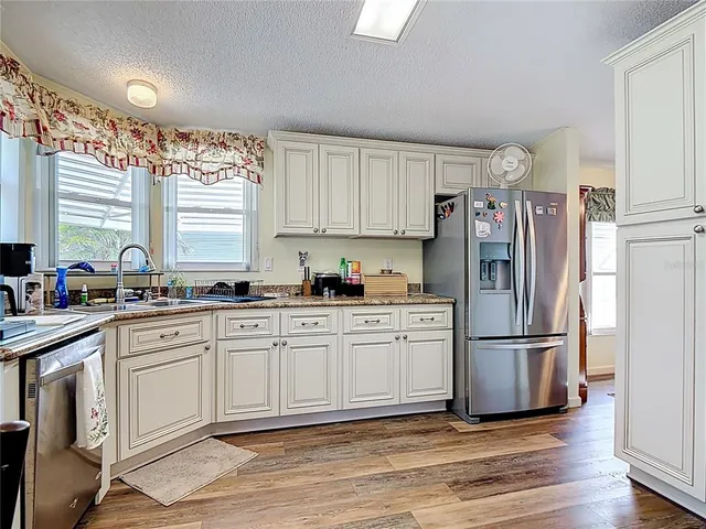 a kitchen with stainless steel appliances granite countertop a refrigerator sink and cabinets