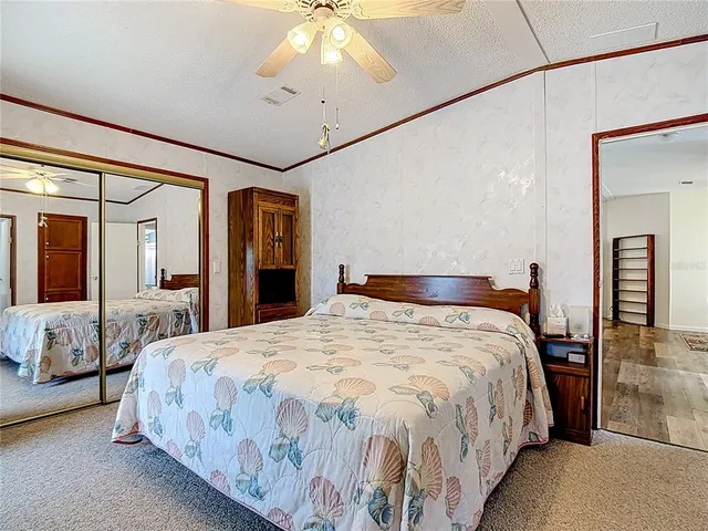 a bedroom with a large bed and a chandelier