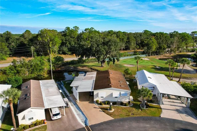 an aerial view of a house with garden space ocean and mountain view in back