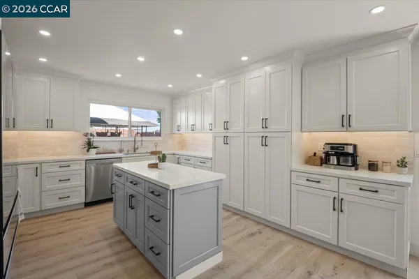a kitchen with white cabinets and white appliances