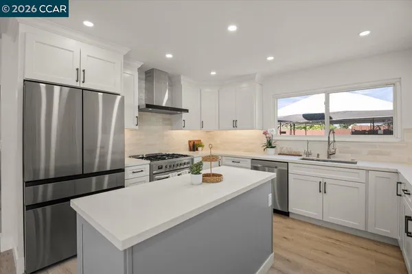 a kitchen with stainless steel appliances a stove a sink a refrigerator and cabinets