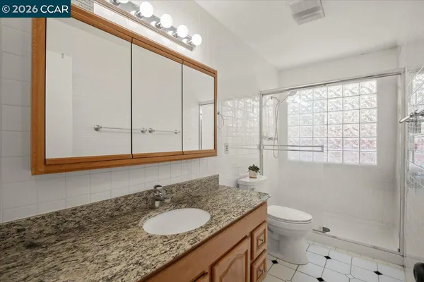 a bathroom with a granite countertop sink and a mirror