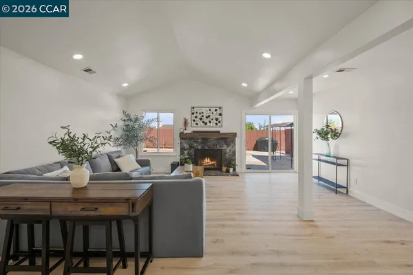 a living room with fireplace furniture and a potted plant