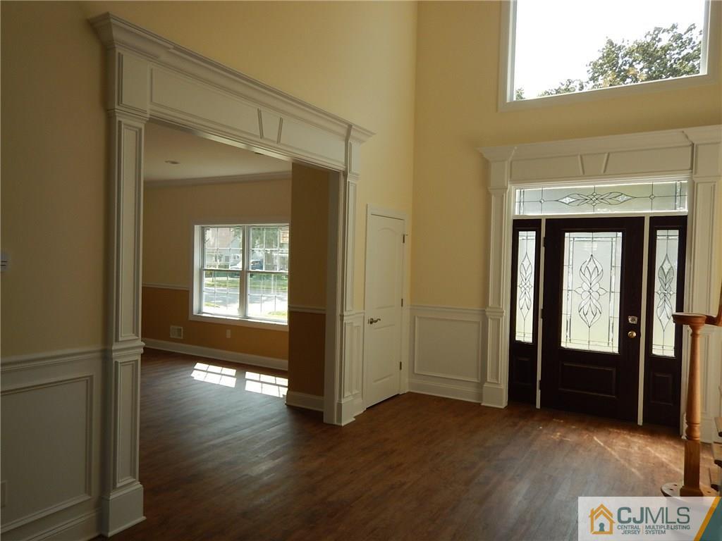 62 Idlewild Road Edison, NJ 08817 - Photo 3 of 11 an empty room with wooden floor and windows