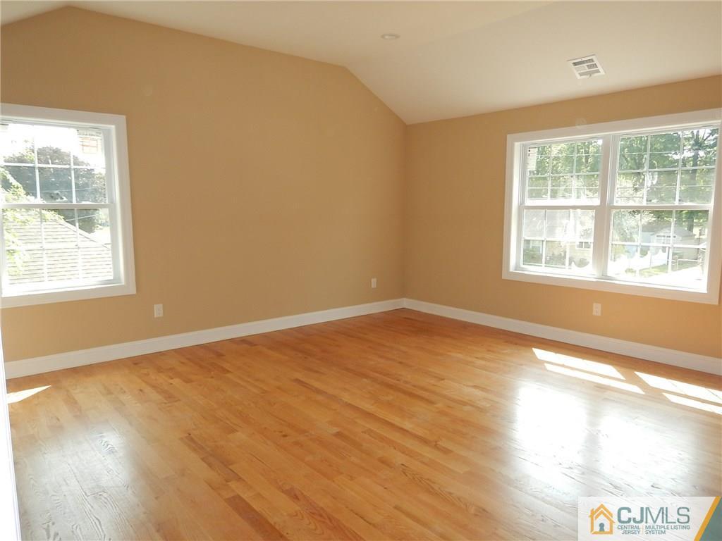 62 Idlewild Road Edison, NJ 08817 - Photo 8 of 11 an empty room with wooden floor and windows