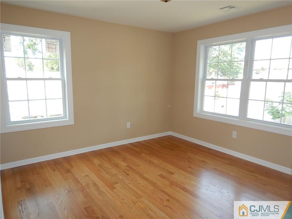 62 Idlewild Road Edison, NJ 08817 - Photo 9 of 11 a view of an empty room with wooden floor and a window