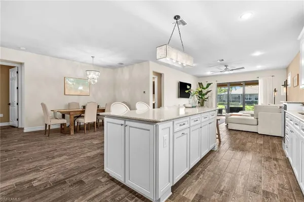 a large white kitchen with sink and refrigerator