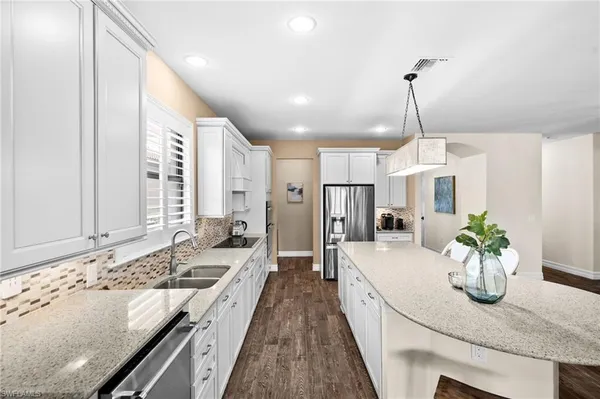 a large kitchen with kitchen island granite countertop a sink stainless steel appliances and cabinets