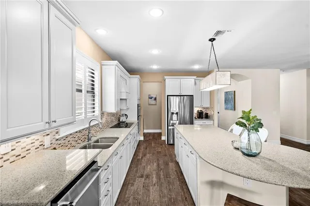 a large kitchen with kitchen island granite countertop a sink stainless steel appliances and cabinets