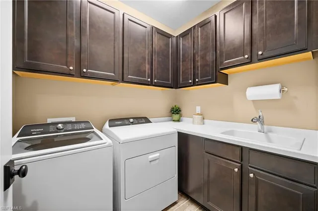 a utility room with sink dryer and washer