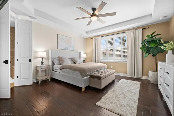 a bedroom with a bed chandelier and a window