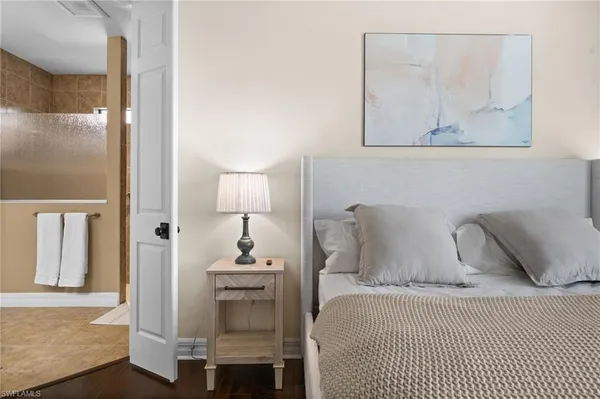 a bedroom with a bed and painting on the wall