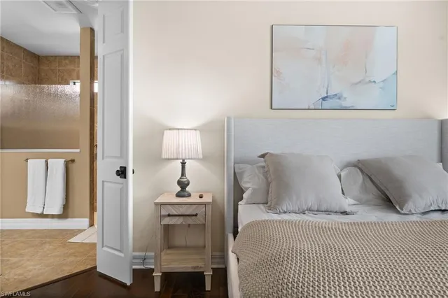 a bedroom with a bed and painting on the wall