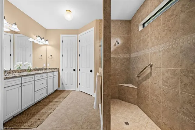 a spacious bathroom with a granite countertop sink mirror and shower
