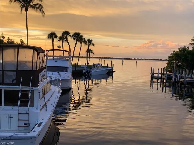 a view of a ocean with boats and palm trees