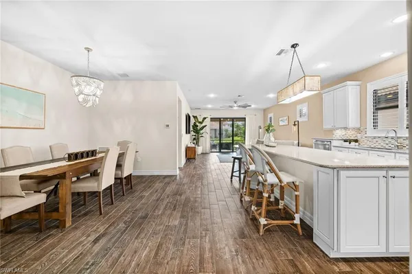 a very nice looking dining room with a large window and wooden floor