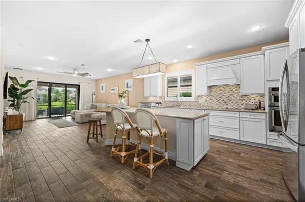 a kitchen with stainless steel appliances kitchen island granite countertop a stove a sink and a refrigerator