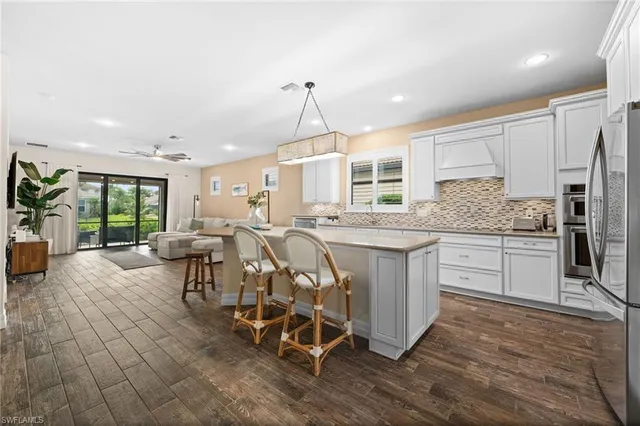 a kitchen with stainless steel appliances kitchen island granite countertop a stove a sink and a refrigerator