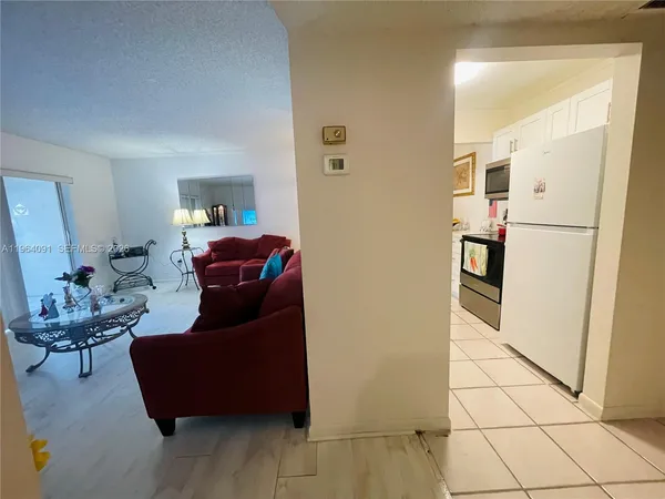 a living room with furniture and a refrigerator