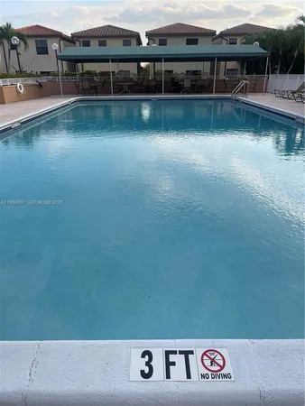 a view of a patio with swimming pool and lounge chairs
