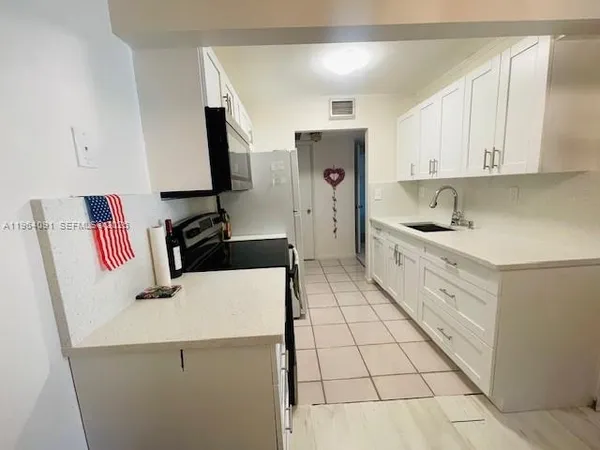 a kitchen with a sink appliances and cabinets