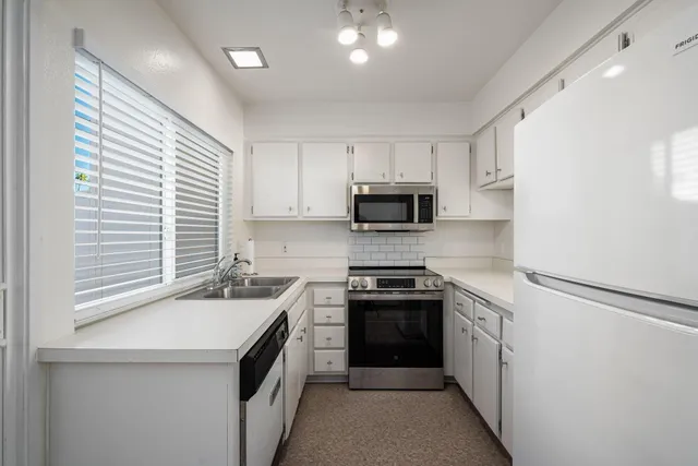 a kitchen with a sink a stove and cabinets