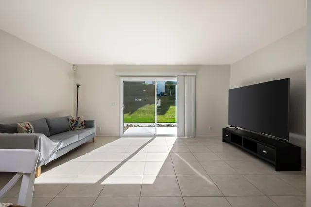 a living room with furniture and a dining table with chairs