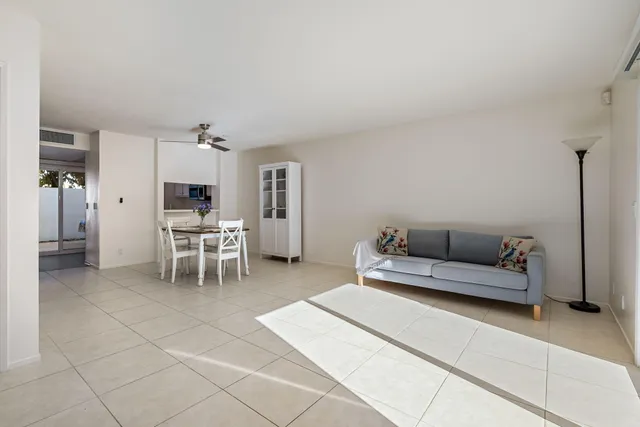 a living room with furniture a flat screen tv and kitchen view