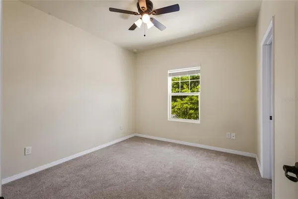 an empty room with a window and a fan
