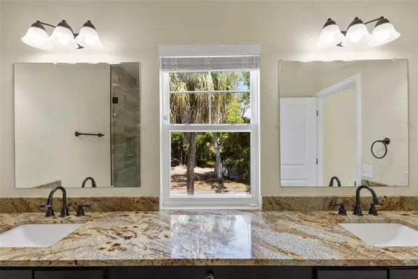 a bathroom with a granite countertop sink and a mirror