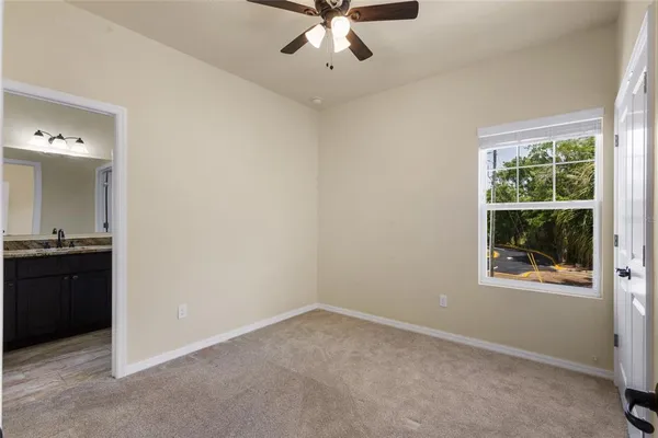 an empty room with fan and windows