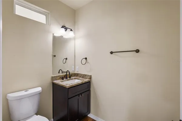 a bathroom with a granite countertop sink a toilet and a mirror