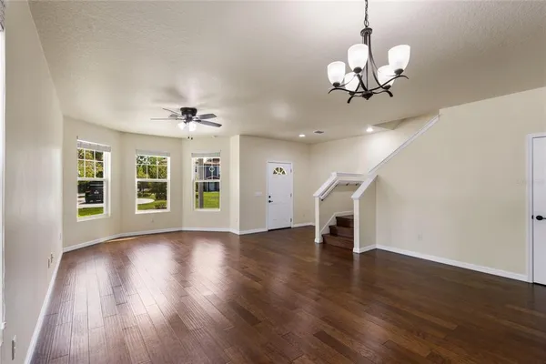 a view of a livingroom with wooden floor and a ceiling fan