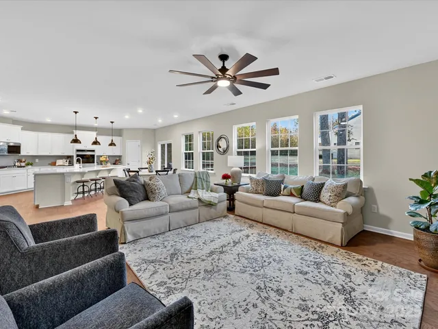 a living room with furniture and a view of kitchen