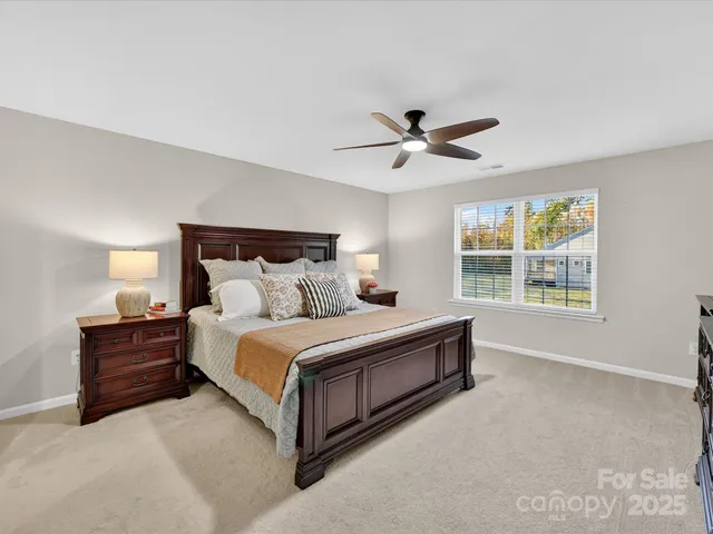 a spacious bedroom with a bed and a large window