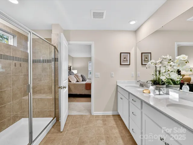 a en suite bathroom with a double vanity sink and a mirror
