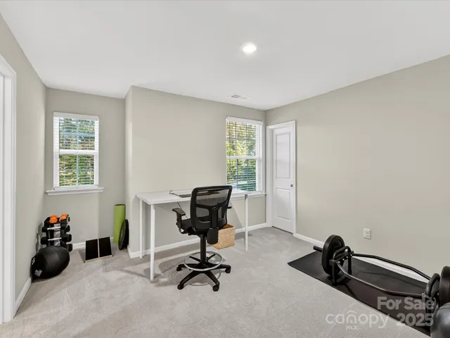 a view of a workspace with furniture and a window