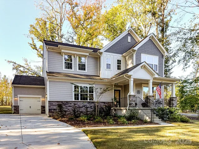 a front view of a house with a yard outdoor seating and garage