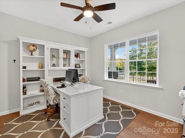 a view of a workspace with furniture and a window
