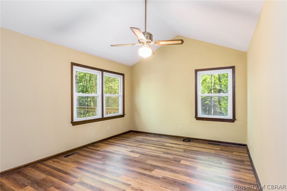 10060 Figg Shop Road Gloucester, VA 23061 - Photo 19 of 38 Spacious and bright owner's suite with views of the rear deck and yard, a cathedral ceiling, and ensuite bath.