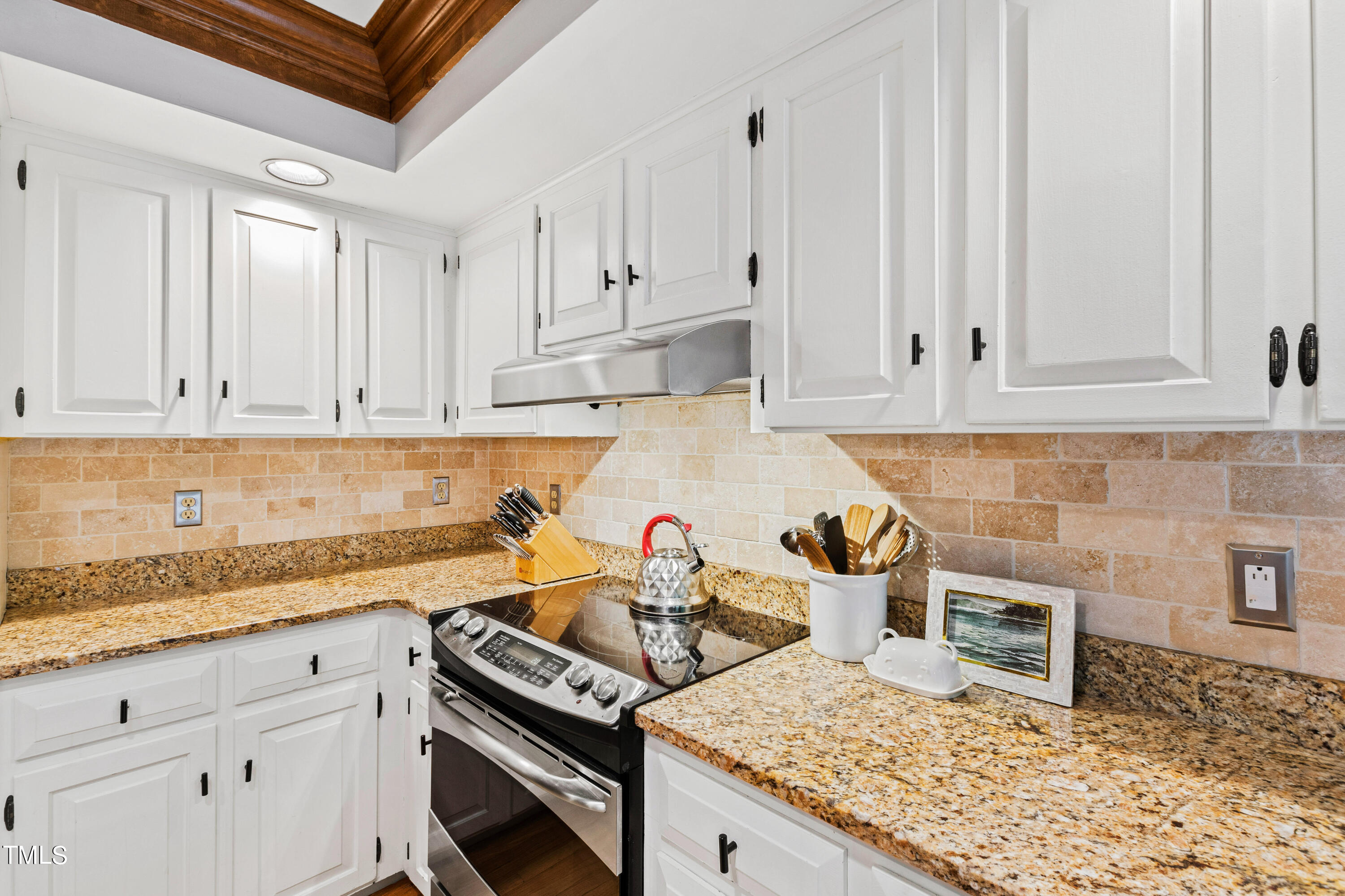 3405 Stallion Court Raleigh, NC 27613 - Photo 18 of 55 a kitchen with granite countertop white cabinets and a stove