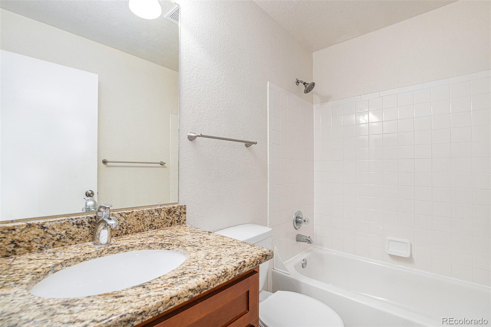 5253 Wangaratta Way Highlands Ranch, CO 80130 - Photo 17 of 43 a bathroom with a granite countertop sink toilet and shower